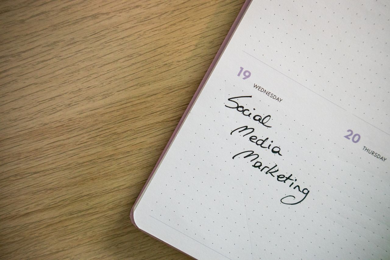 Close-up view of a notebook page with Social Media Marketing written on it.